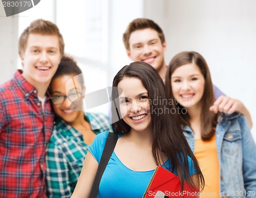 Image of smiling student with bag, folders and tablet pc