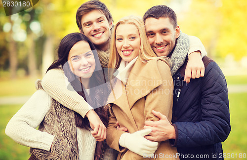 Image of group of friends having fun in autumn park