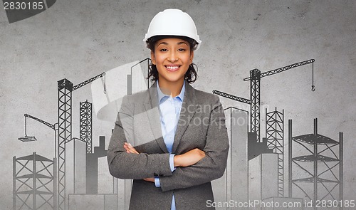 Image of businesswoman in white helmet with crossed arms