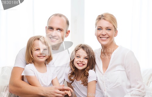 Image of smiling parents and two little girls at home