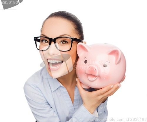 Image of happy businesswoman in eyeglasses with piggy bank