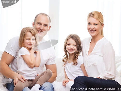 Image of smiling parents and two little girls at new home