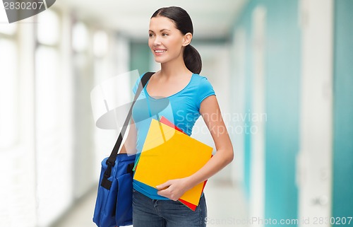 Image of smiling female student with bag and folders