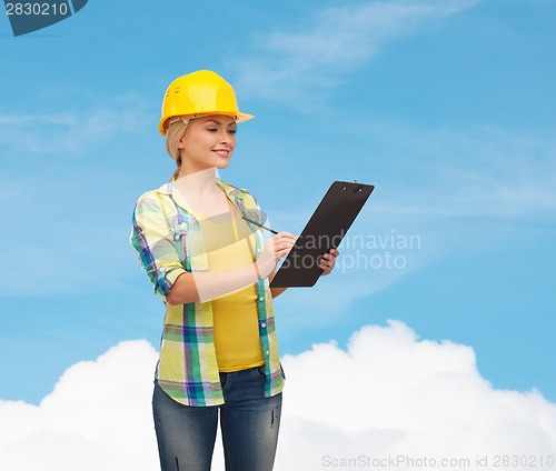 Image of smiling woman in helmet with clipboard