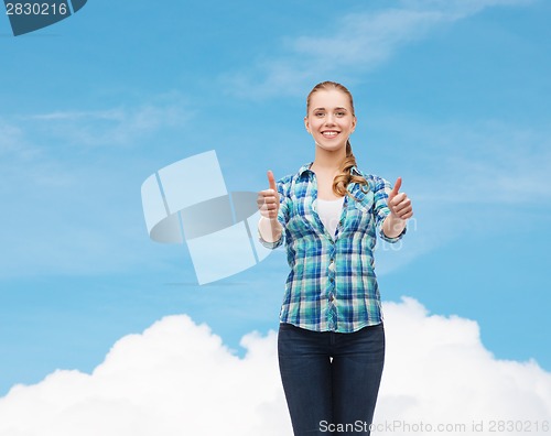 Image of young woman in casual clothes showing thumbs up