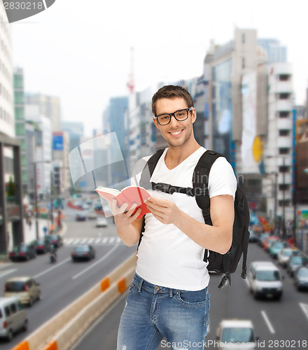 Image of travelling student with backpack and book