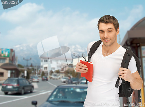 Image of travelling student with backpack and book