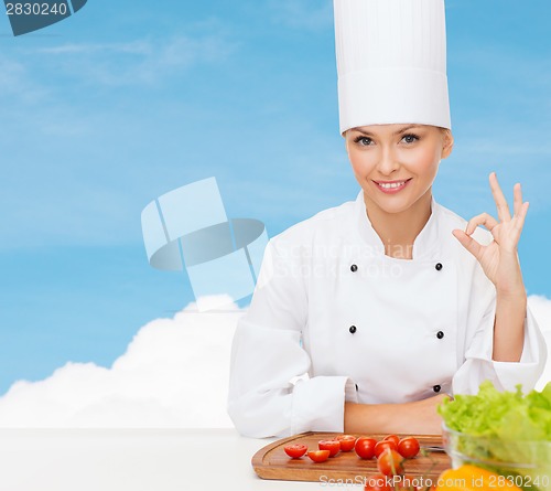 Image of female chef with vegetables showing ok sign