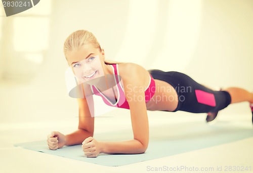 Image of sporty woman doing exercise on the floor