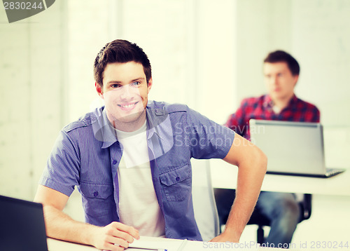 Image of smiling student with laptop at school