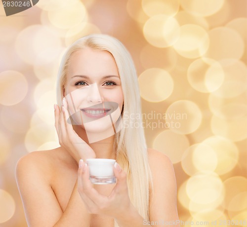 Image of woman applying cream on her skin