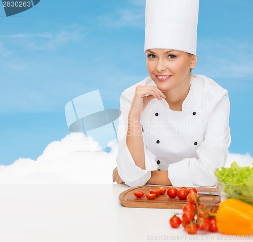 Image of smiling female chef with vegetables