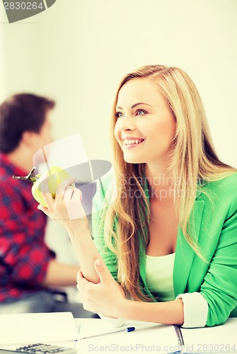 Image of student girl with green apple in college