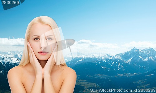 Image of face of beautiful woman touching her face skin