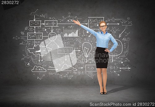 Image of smiling businesswoman in glasses pointing her hand