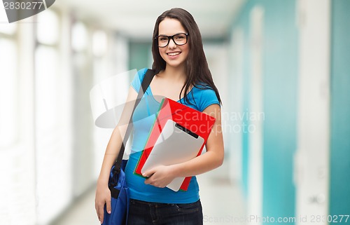 Image of smiling student with bag, folders and tablet pc