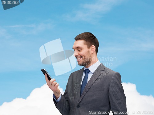 Image of young smiling businessman with smartphone
