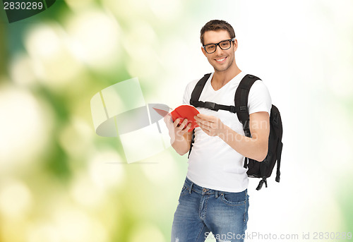 Image of travelling student with backpack and book