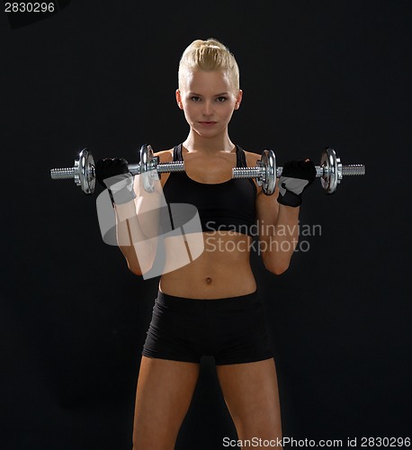 Image of sporty woman with heavy steel dumbbells