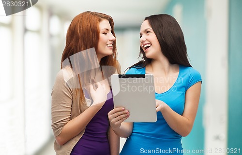 Image of two smiling teenagers with tablet pc computer