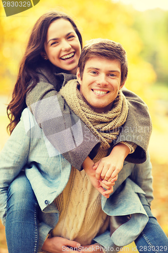 Image of romantic couple playing in the autumn park