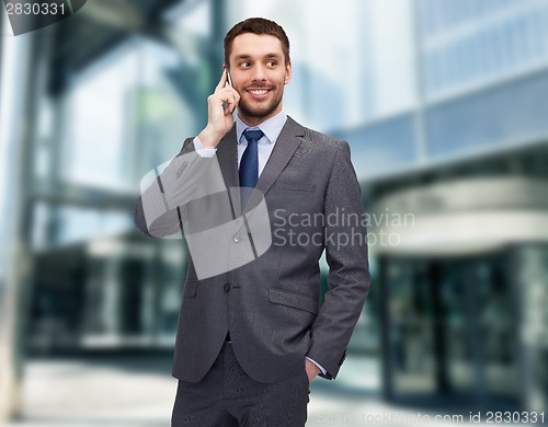 Image of young smiling businessman with smartphone