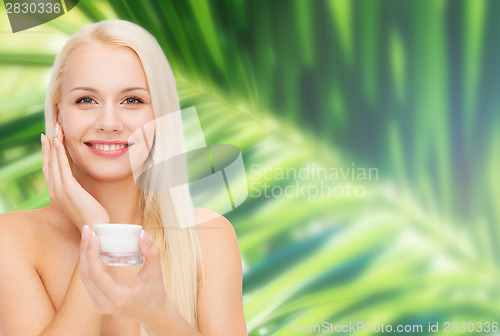 Image of woman applying cream on her skin