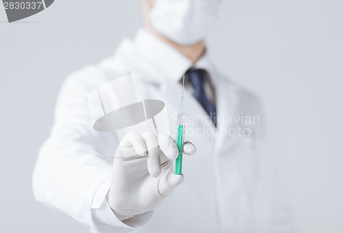 Image of male doctor holding syringe with injection