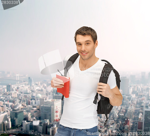 Image of travelling student with backpack and book