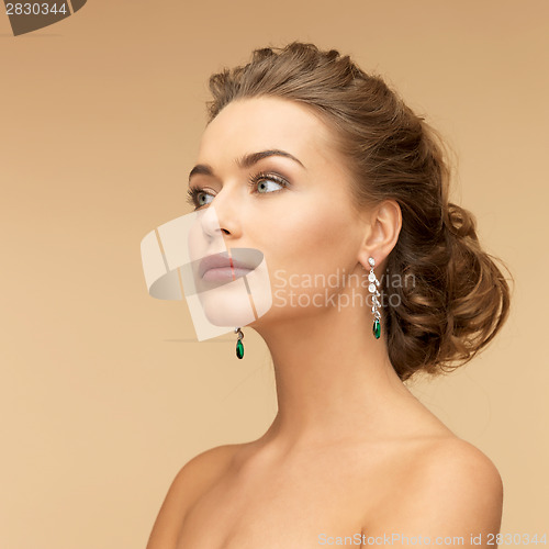 Image of woman with diamond and emerald earrings