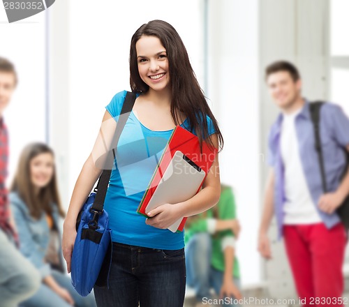 Image of smiling student with bag, folders and tablet pc