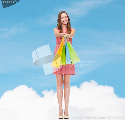 Image of smiling woman in dress with many shopping bags