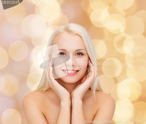 Image of face of beautiful woman touching her face skin