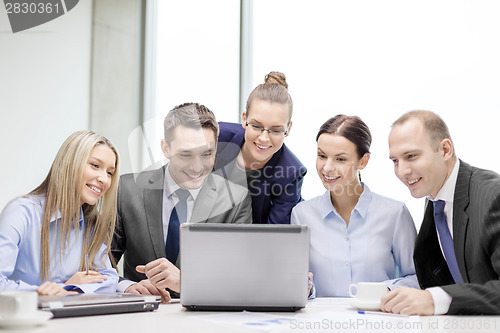 Image of business team with laptop having discussion