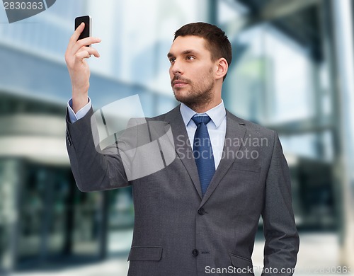 Image of young businessman with smartphone