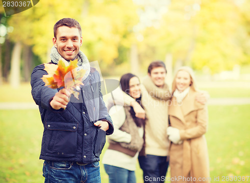 Image of group of friends having fun in autumn park