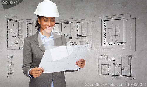 Image of businesswoman in white helmet with blueprint