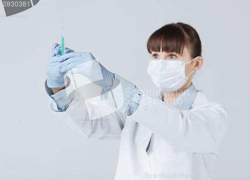 Image of female doctor holding syringe with injection