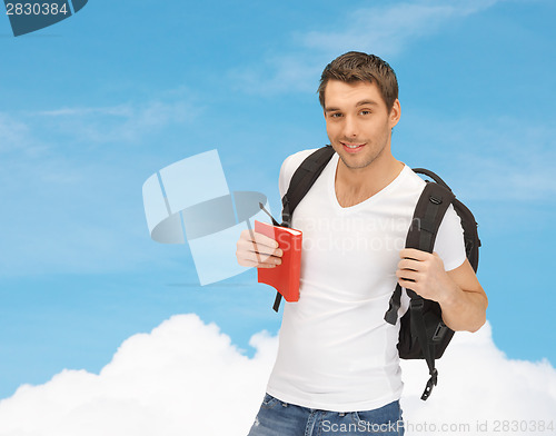 Image of travelling student with backpack and book