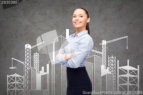 Image of young smiling businesswoman with crossed arms