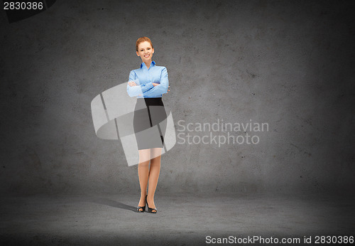 Image of young smiling businesswoman with crossed arms