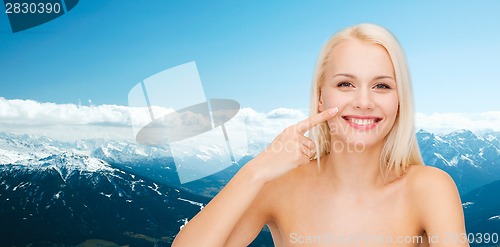 Image of smiling young woman pointing to her nose