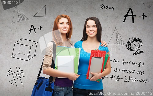 Image of two smiling students with bag, folders and tablet