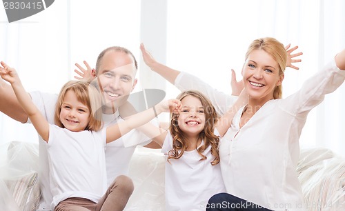 Image of smiling parents and two little girls at new home