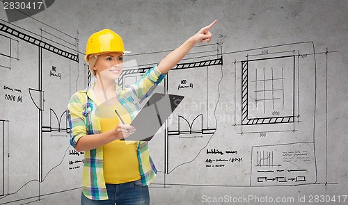 Image of smiling woman in helmet with clipboard