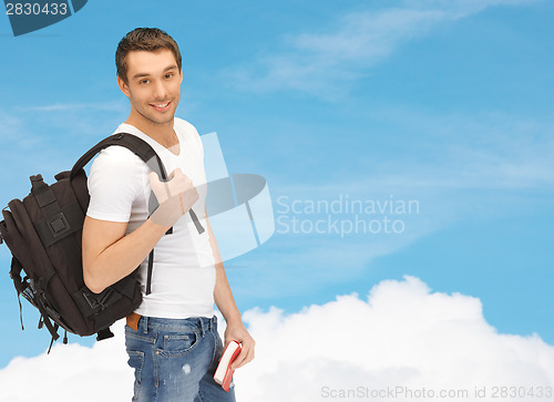 Image of travelling student with backpack and book