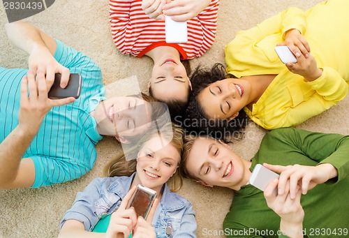 Image of group of smiling people lying down on floor