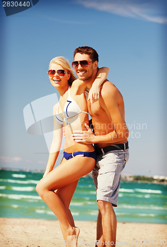 Image of happy couple in sunglasses on the beach