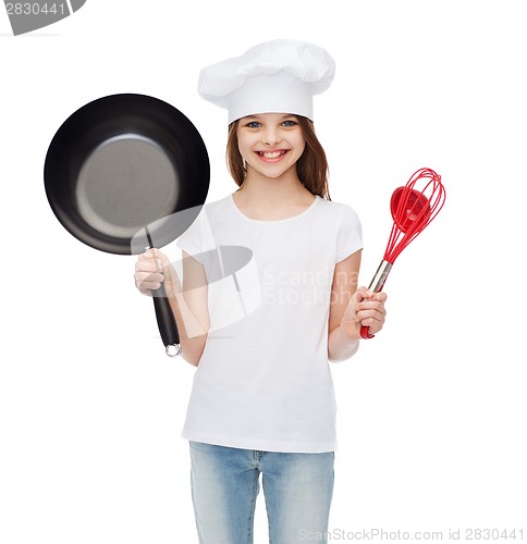Image of smiling girl in cook hat with ladle, whisk and pan