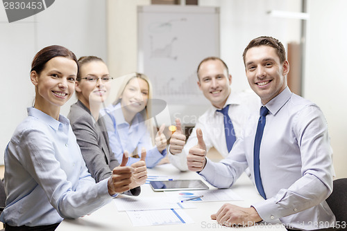 Image of business team showing thumbs up in office